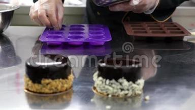 两个单份蛋糕放在桌子上，一个<strong>糖果盒</strong>放在硅饼模具后面